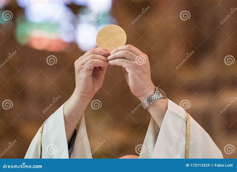Sacerdote che esegue il rito della commistione eucaristica durante la Messa