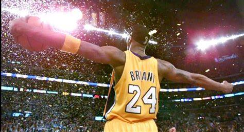 Kobe Bryant festeggia una vittoria con i Los Angeles Lakers, con il trofeo NBA in mano.