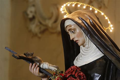 Statua o immagine di Santa Rita che tiene in mano una rosa