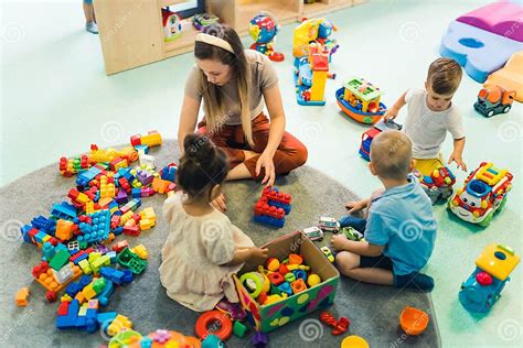 Foto di bambini che giocano e imparano in un'aula di una scuola paritaria, sotto la supervisione di educatori