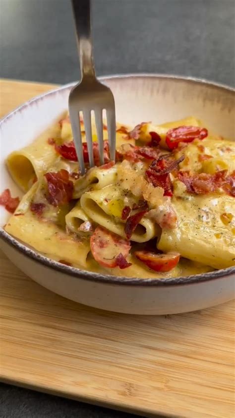 Piatto di paccheri con speck croccante, pesto e pomodorini