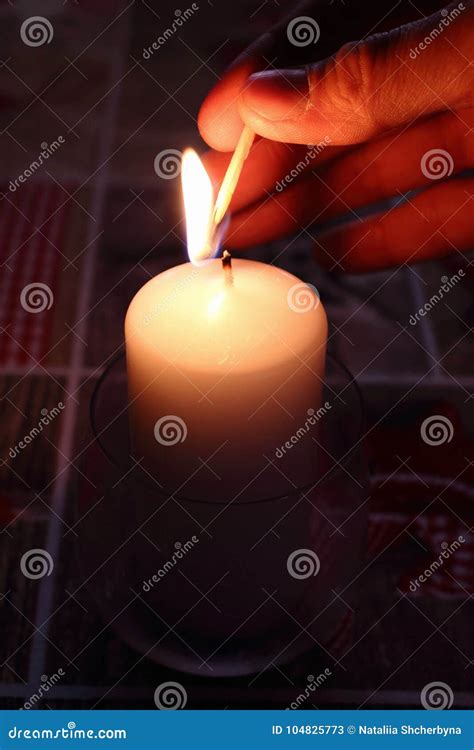 Mano che accende una candela, simbolo di luce e speranza divina