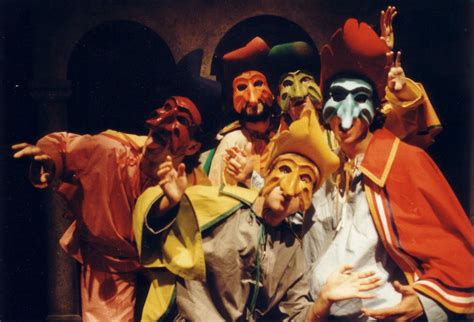 Scena teatrale di una commedia dell'arte goldoniana, con attori in costume e maschere tradizionali.