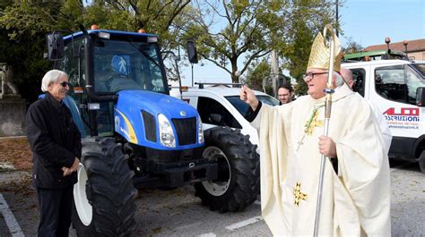 Monsignor Cesare Cancarini benedice una fila di trattori.
