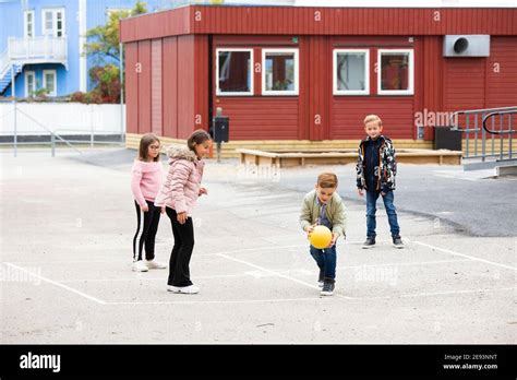 Foto esterna di una moderna scuola dell'infanzia con bambini che giocano nel cortile