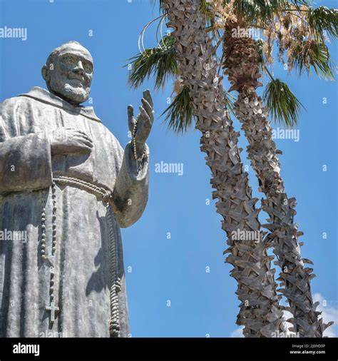 Foto della statua di Padre Pio con maschera di carnevale
