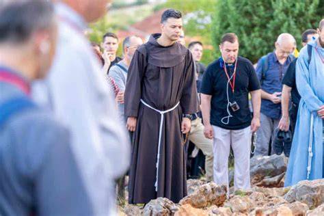 Persone in preghiera con il rosario sulla Collina delle Apparizioni a Medjugorje