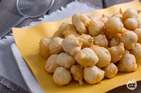 Foto di un cestino di pettole fritte, alcune cosparse di zucchero a velo