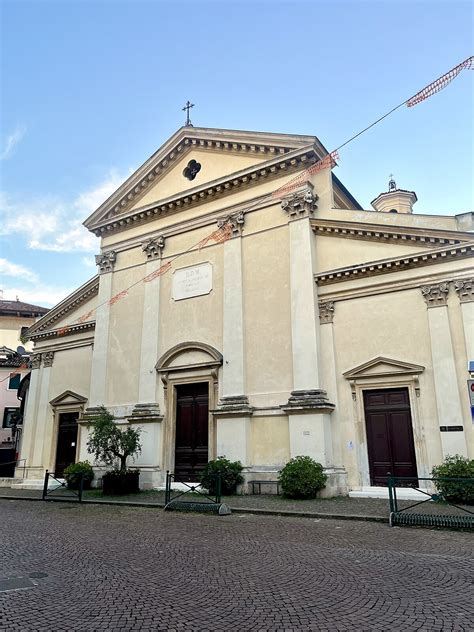 Esterno della Chiesa di Sant'Andrea Apostolo a Cavasagra, evidenziando lo stile neoclassico e il prato circostante.