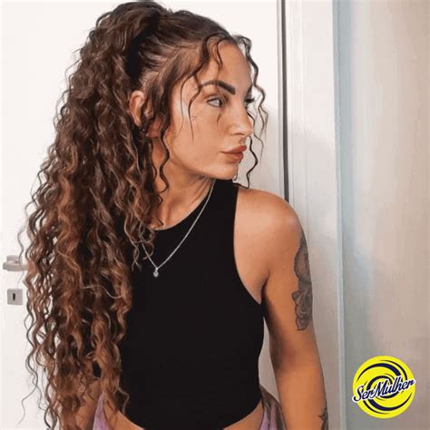 Ragazza con capelli ricci afro raccolti in una coda alta voluminosa.