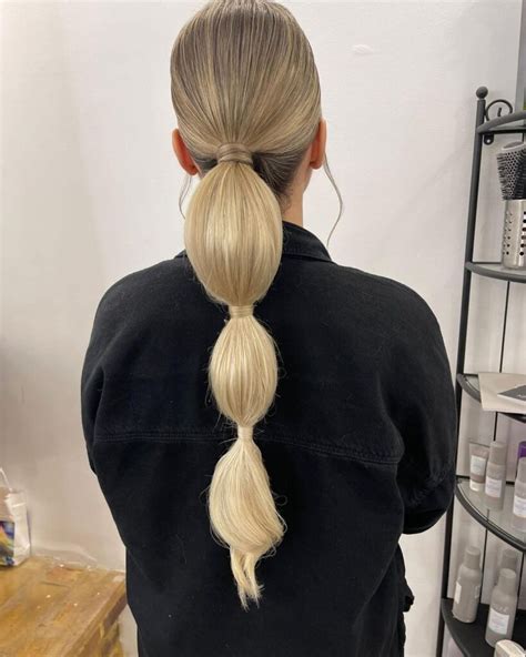 Angela Bassett con una coda bassa e radici sleek su capelli ricci.