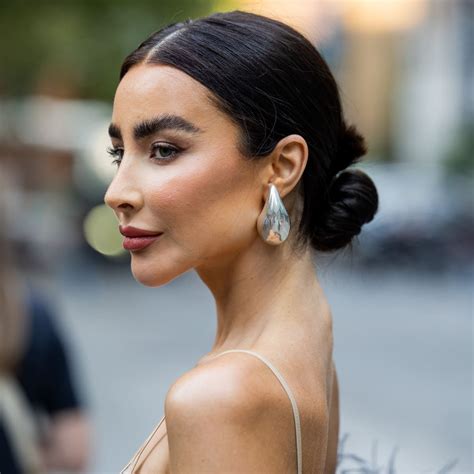 Ragazza con lunghi capelli ricci raccolti in uno chignon basso e morbido.