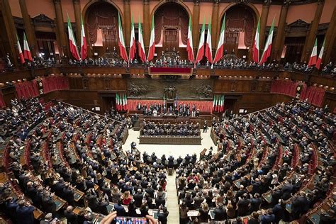 Tribuna di oratori nel Parlamento italiano con un cartello simbolico sul Decreto Sicurezza