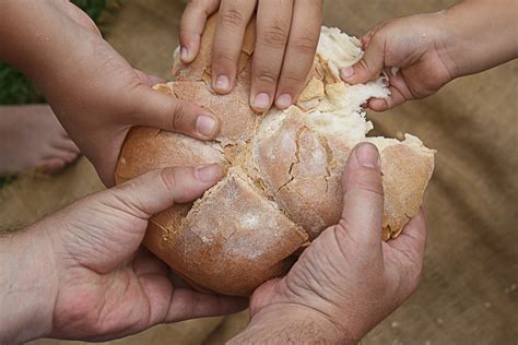 persone che condividono il pane in un contesto comunitario