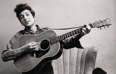 Ritratto giovanile di Bob Dylan con la sua chitarra acustica
