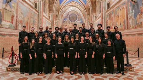 Foto di un grande coro giovanile che si esibisce in un contesto ecclesiastico