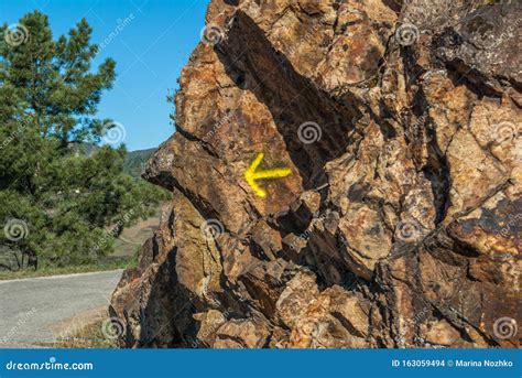 Freccia gialla dipinta su una roccia sul Cammino di Santiago