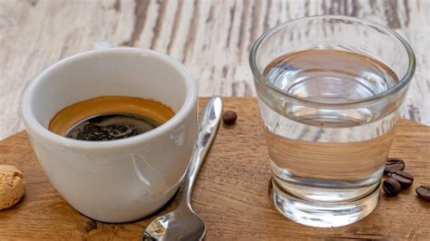 Immagine ravvicinata di un espresso servito con un bicchiere d'acqua in un caffè tradizionale