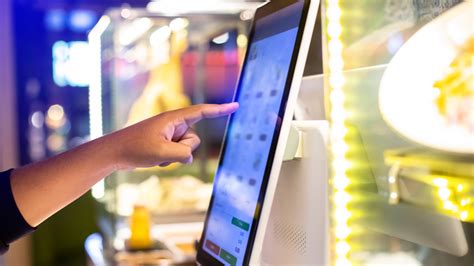 Foto di un chiosco digitale McDonald's con un cliente che effettua un ordine