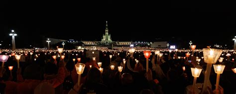 Foto di pellegrini con candele accese durante la fiaccolata a Fatima
